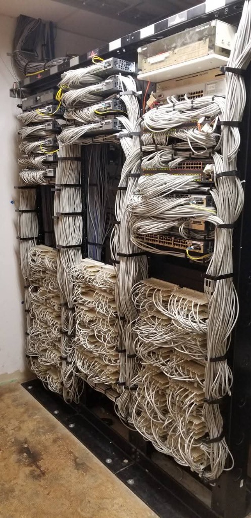 Commercial multi-bay server rack cleanly dressed into vertical cable managers after Aaron Tech cleanup